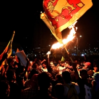 A protestor holds a torch during a demonstration against the economic crisis at the entrance of the president\'s office in Colombo on Wednesday. | AFP-JIJI