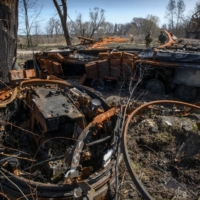 Ukrainian service members stand next to a tank destroyed during Russia\'s invasion, in the village of Termakhivka, in the Kyiv region, on Thursday. | REUTERS
