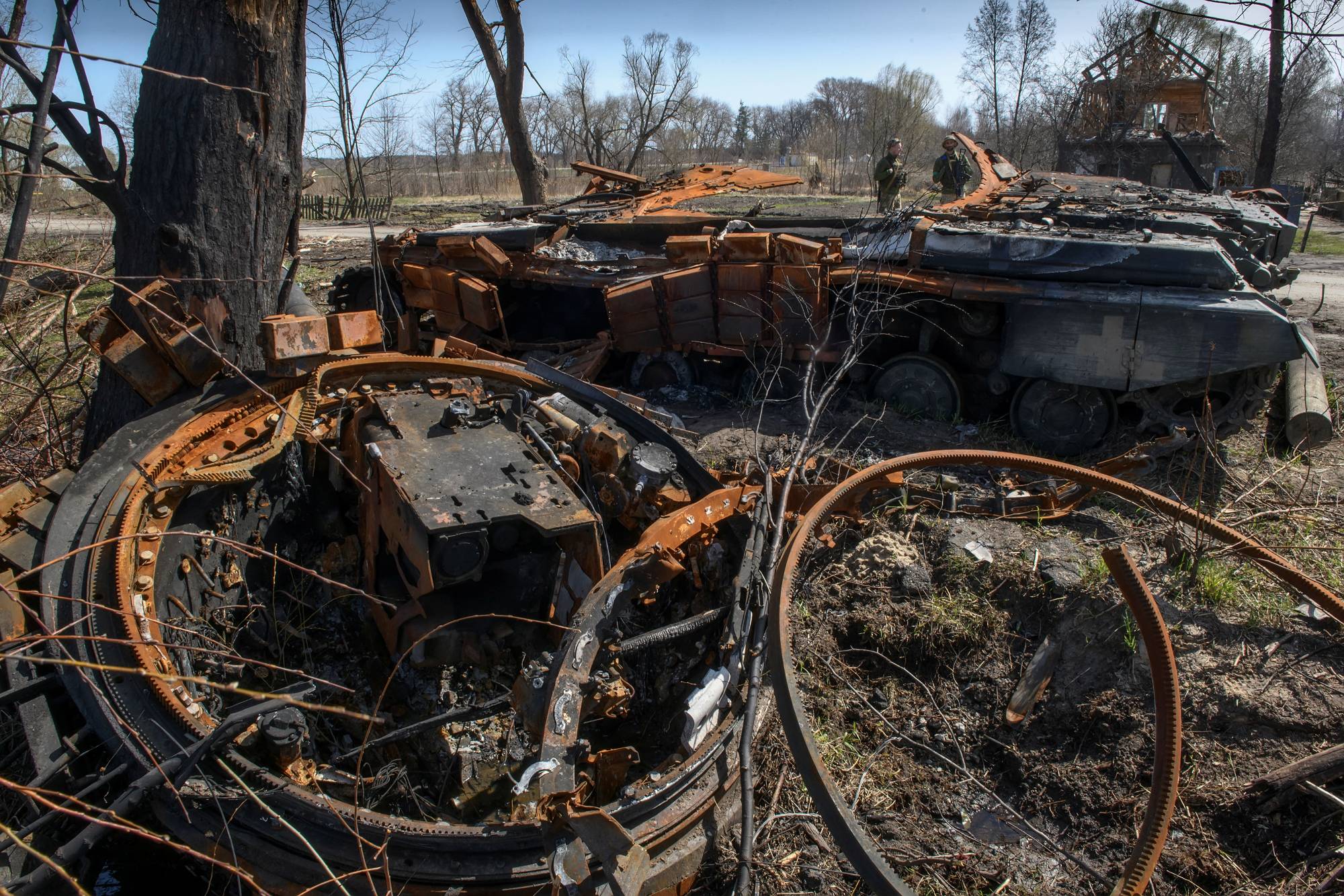 Ukrainian service members stand next to a tank destroyed during Russia's invasion, in the village of Termakhivka, in the Kyiv region, on Thursday. | REUTERS