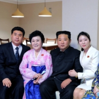 North Korean leader Kim Jong Un poses with announcer Ri Chun Hee (second from left) and her family at a house in the Pothong Riverside terraced residential district in Pyongyang on Wednesday. | KCNA / KNS / VIA AFP-JIJI