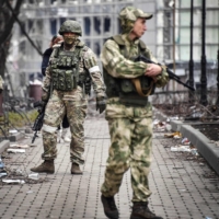Russian soldiers walks along a street in Mariupol, Ukraine, on Tuesday.  | AFP-JIJI