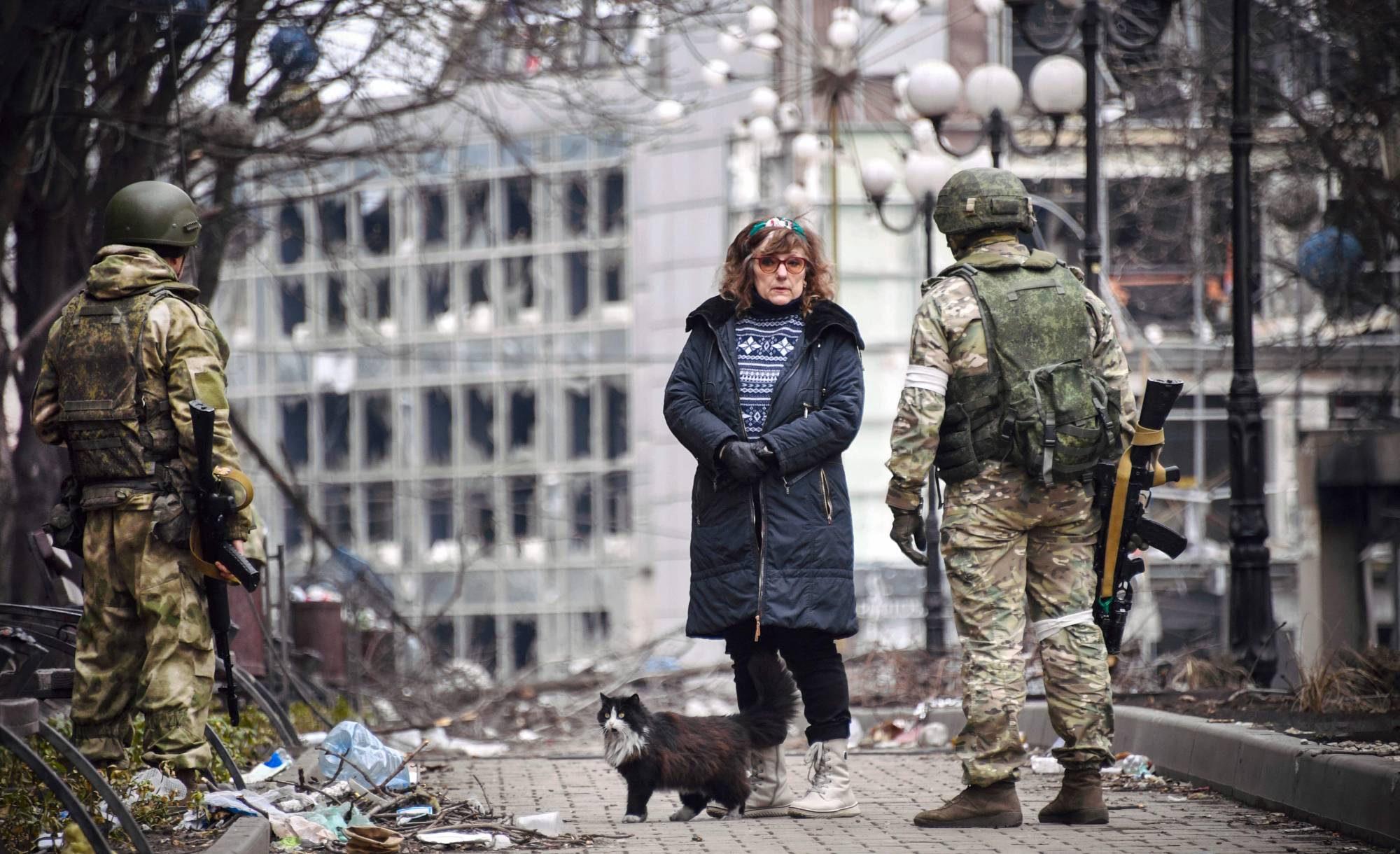 A woman talks with Russian soldiers in Mariupol, Ukraine, on April 12 as Russian troops intensify a campaign to take the strategic port city. | AFP-JIJI