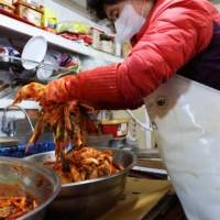 Choi Sun-hwa makes kimchi at her side dish store at a traditional market in Seoul, South Korea. | REUTERS
