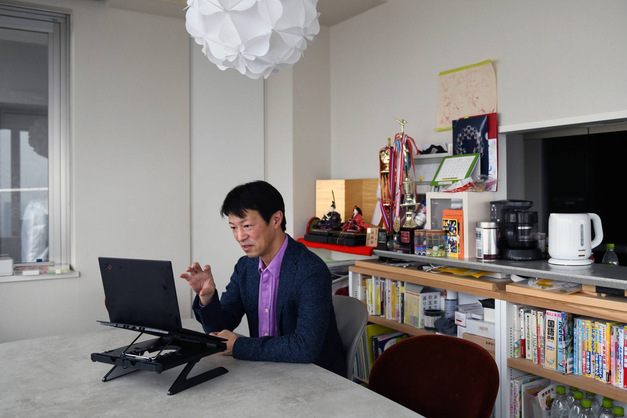 Takahiro Harada meets remotely with a client from his home in Tokyo on April 3. Harada took early retirement and started his own personal coaching business.  | NORIKO HAYASHI/THE NEW YORK TIMES