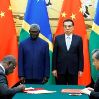 Solomon Islands Prime Minister Manasseh Sogavare (seated left), Solomon Islands Foreign Minister Jeremiah Manele (standing left), Chinese Premier Li Keqiang and Chinese State Councillor (standing right) and Foreign Minister Wang Yi attend a signing ceremony at the Great Hall of the People in Beijing in 2019.  | REUTERS