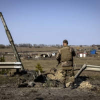 A Ukrainian soldier looks at the remnants of a Russian T90 tank that was said to have been destroyed using an American-made Javelin missile at a front-line position in Kyiv on March 25.  | IVOR PRICKETT / THE NEW YORK TIMES