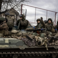 Ukrainian troops and armored vehicles roll through the recently recaptured town of Bucha, northwest of Kyiv, on April 6. | IVOR PRICKETT / THE NEW YORK TIMES
