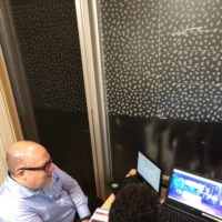 Michael Clemons gives an older child a computer programming lesson.