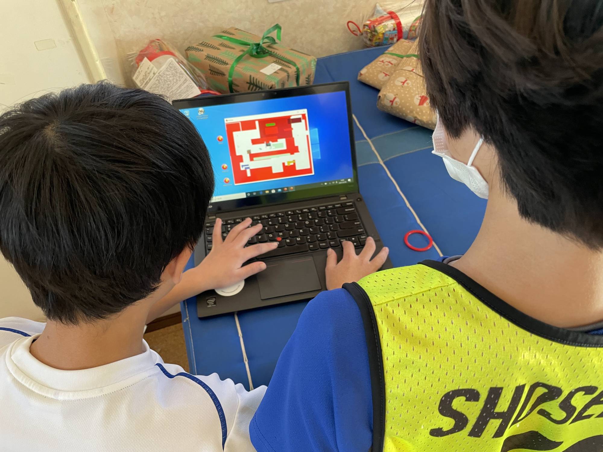 A YouMeWe volunteer helps a young boy develop his computer skills at the Designing Artists Academy. | 