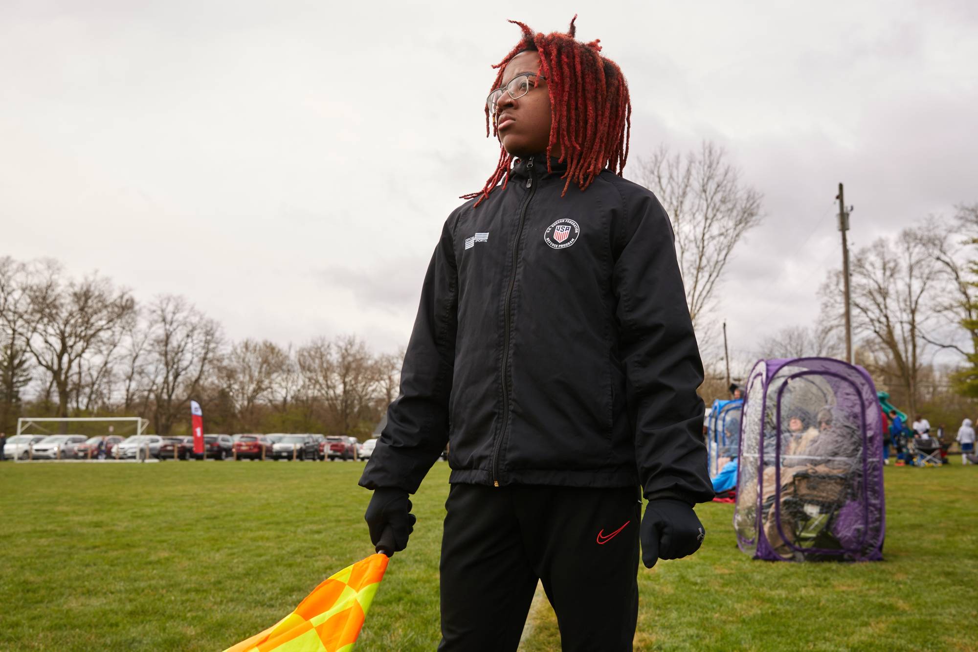 Tyrek Greene serves as a line judge at a youth soccer match in Fairfield, Ohio, on April 9. For years, unruly parents have turned youth sporting events into a toxic environment — the cancellation of games and entire seasons over the last two years hastened an exodus of referees.  | BRIAN KAISER / THE NEW YORK TIMES