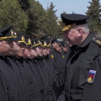 The head of the Russian navy, Adm. Nikolai Yevmenov, meets with people said to be crew members from the sunken Moskva in Sevastopol, Crimea, on April 16.  | RUSSIAN DEFENSE MINISTRY / VIA REUTERS