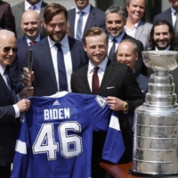 President Joe Biden (left) is presented with a jersey by the Tampa Bay Lighting during their visit to the White House in Washington on Monday. | USA TODAY / VIA REUTERS