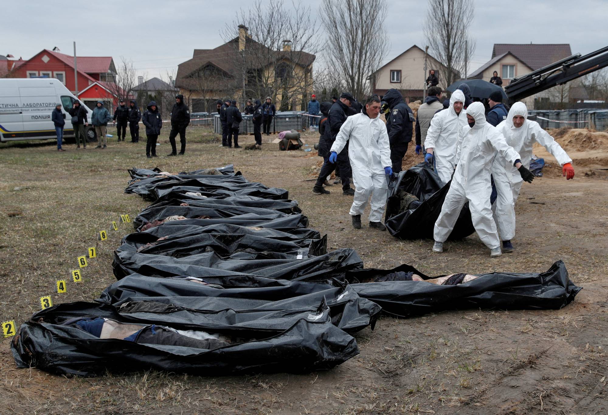 Forensic technicians exhume the bodies of civilians who Ukrainian officials say were killed during Russia's invasion and then buried in a mass grave, in the town of Bucha, outside Kyiv, on April 8. | Reuters 