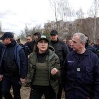 Ukrainian Prosecutor General Iryna Venediktova (center) speaks to a representative of French forensics investigators in Bucha on April 12. | REUTERS 