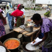 A woman sells plantains fried in crude palm oil, on a street in Abidjan, Ivory coast, on April 12. | REUTERS