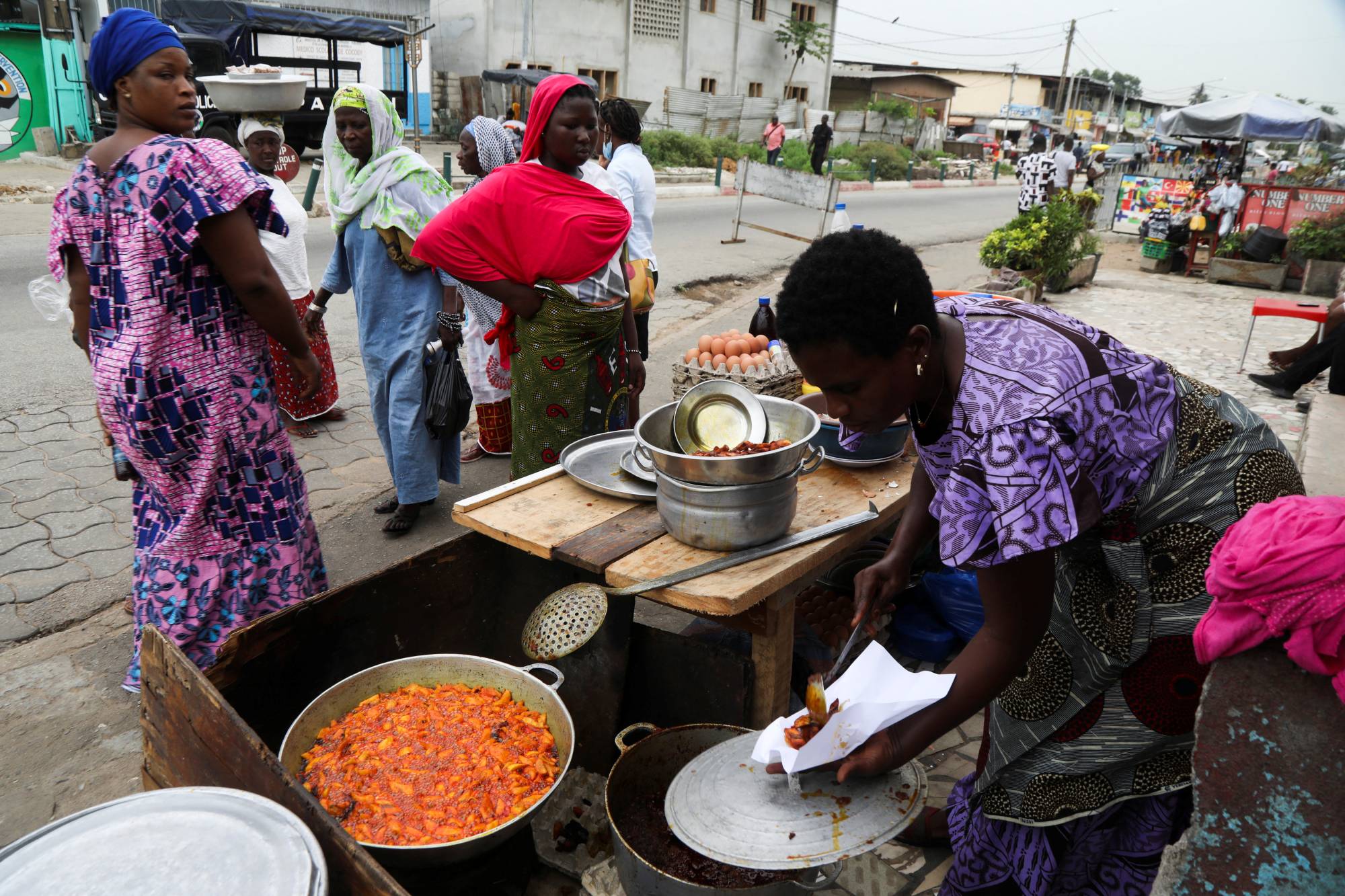 A woman sells plantains fried in crude palm oil, on a street in Abidjan, Ivory coast, on April 12. | REUTERS