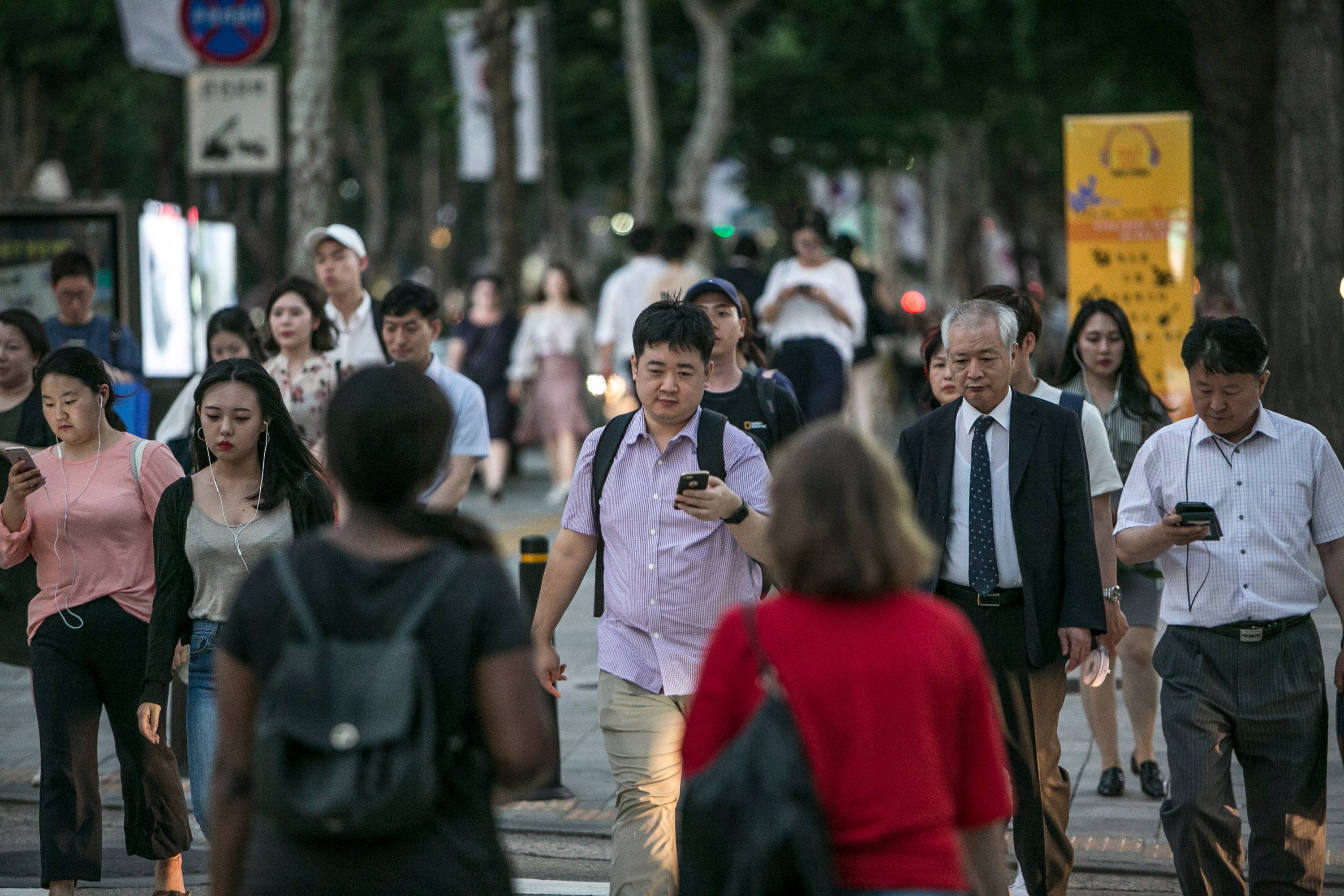 Commuters walk in a business district in Seoul. South Korea has three ways of calculating age, often adding a year or two to the international standard. The incoming president wants to change that.  | JEAN CHUNG/THE NEW YORK TIMES