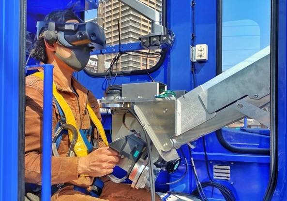 The operator controls the robot from the truck’s cockpit, monitoring the operation through goggles that carry a video feed from a camera attached to the robot's upper half. | JR WEST 