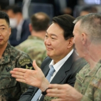 South Korean President-elect Yoon Suk-yeol talks with military officials during his visit to U.S. Army Garrison Humphreys in Pyeongtaek, South Korea, on April 7. | U.S. FORCES KOREA / YONHAP / VIA REUTERS