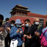 People stand at the entrance of the Forbidden City during the first day of the Labor Day holidays in Beijing on Monday. | AFP-JIJI