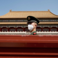 A security guard stands near the entrance of the Forbidden City during the first day of the Labor Day holidays in Beijing on Monday. | AFP-JIJI