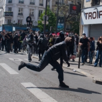 A protester throws a rock during traditional May Day holiday demonstrations on International Workers Day in Paris, on Sunday. | BLOOMBERG