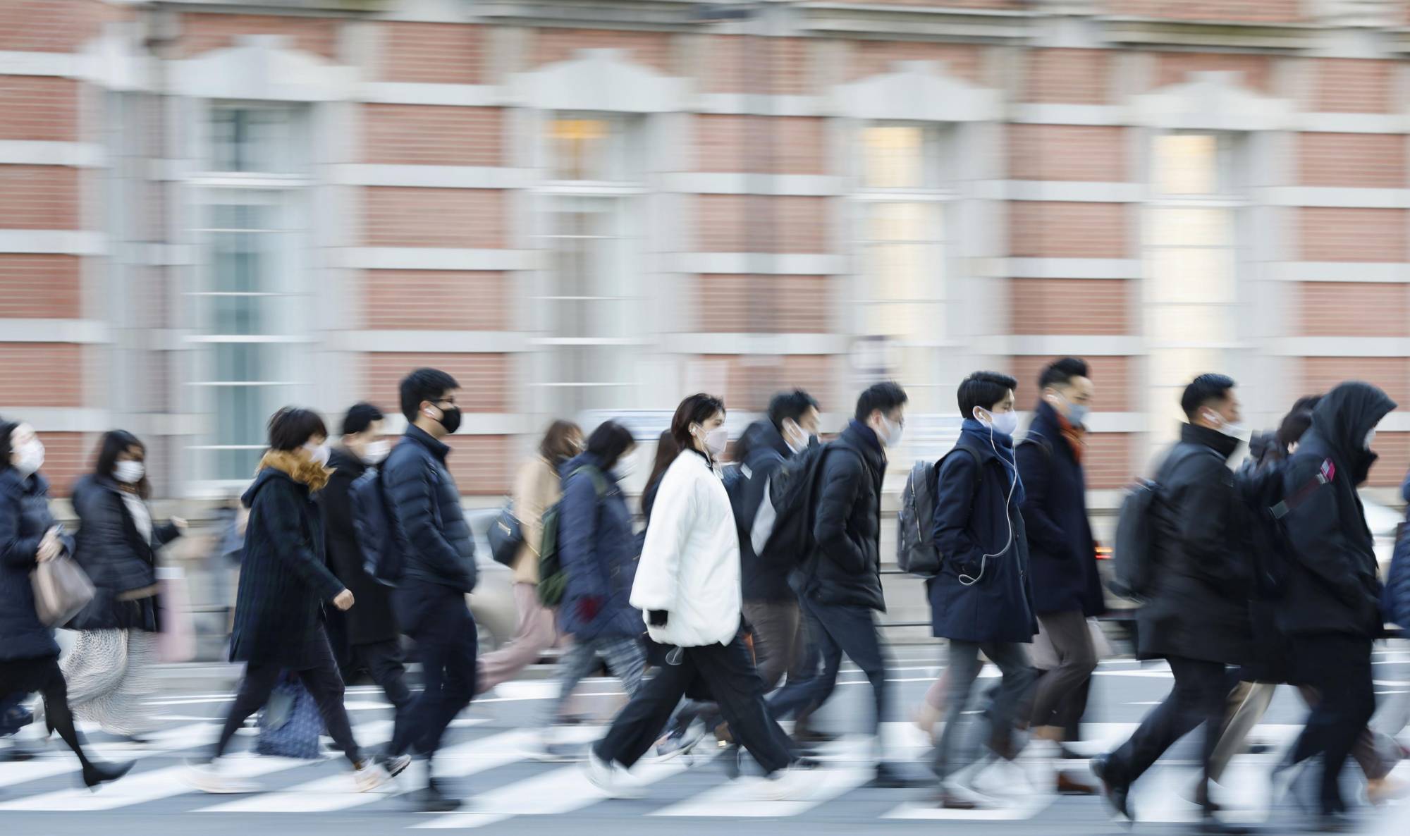 Commuters walk in front of JR Tokyo Station in January. | KYODO