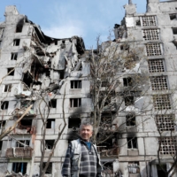 Local resident Sergei Shulgin, 62, in front of a block of flats heavily damaged during the Ukraine-Russia conflict, in Mariupol, Ukraine, on Tuesday  | REUTERS