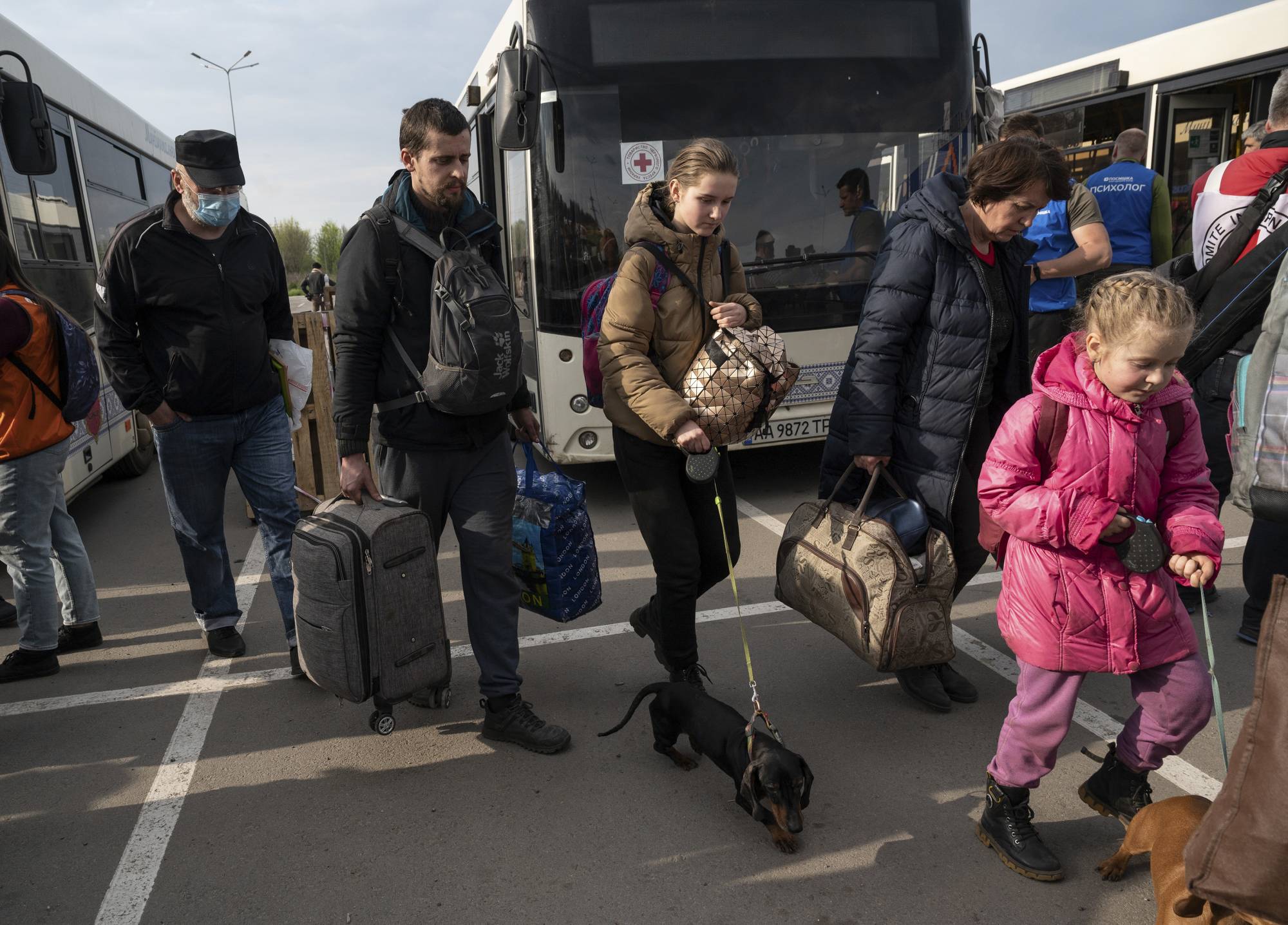 Evacuees from areas around Mariupol arrive with their belongings in Zaporizhzhia, Ukraine, on Tuesday. On a fleet of city buses, flanked by white United Nations and Red Cross vehicles, just over 150 women and children who sheltered for weeks in the belly of Mariupol’s sprawling steelworks arrived at the relative safety of Ukrainian-controlled territory.  | Lynsey Addario / The New York Times