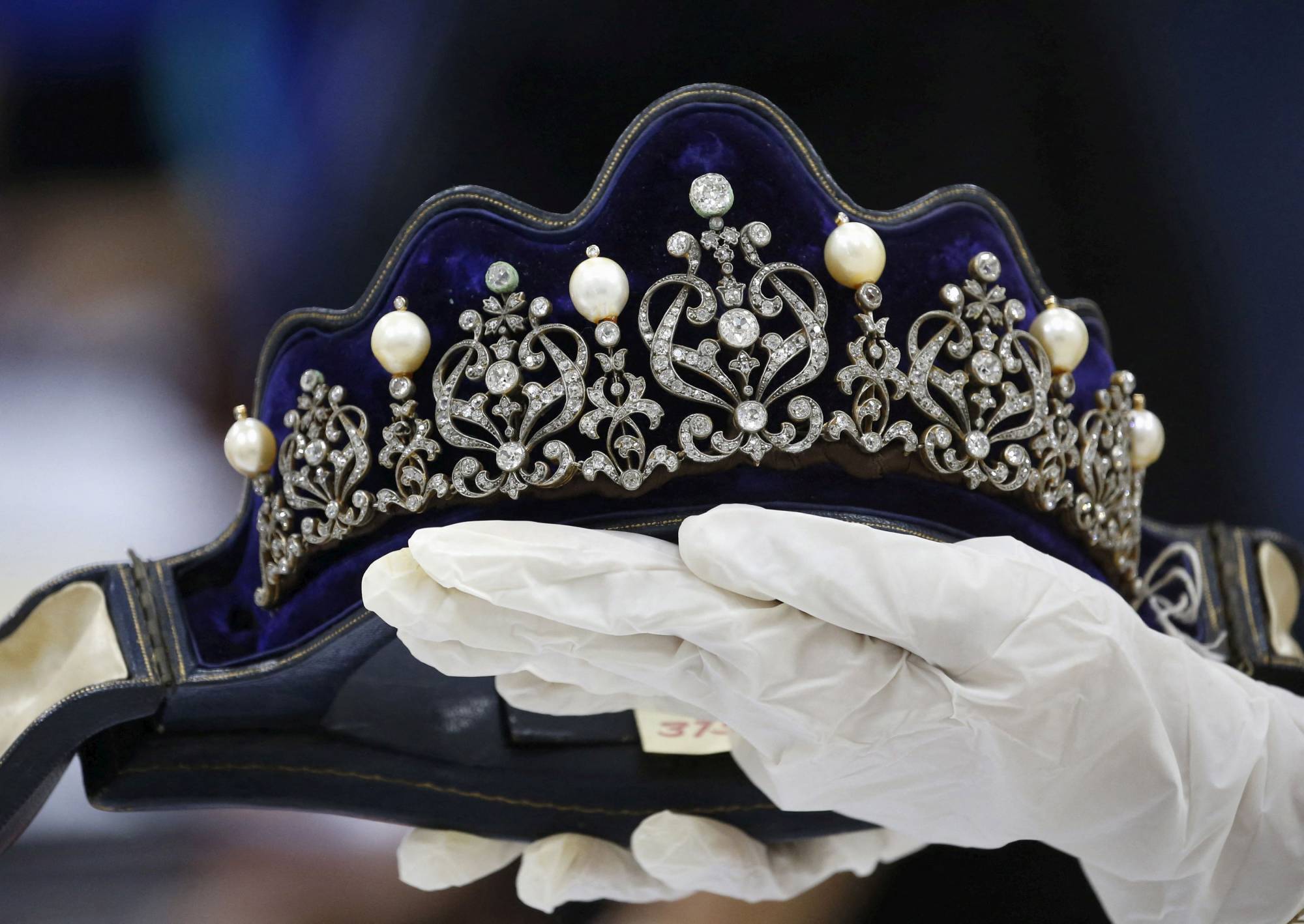 A Presidential Commission on Good Government official displays an item from the confiscated jewelry collection of former Philippine first lady Imelda Marcos. | Reuters 