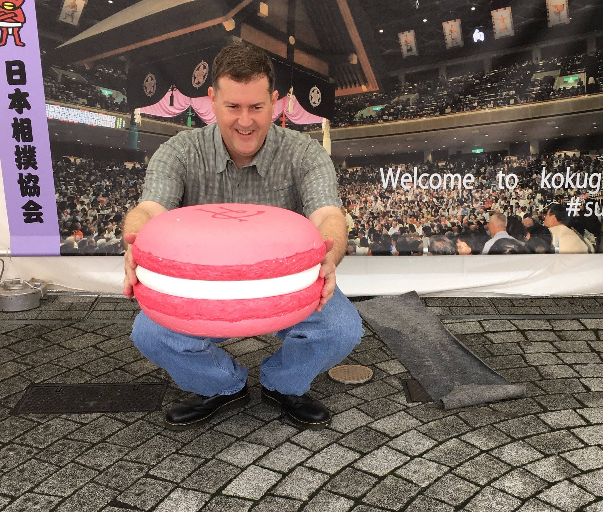 Writer Bruce Henderson of sumo blog Tachiai poses with a giant macaron given as part of the France-Japan Friendship Cup to basho winners in 2016. | Courtesy of Bruce Henderson 