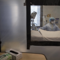 Plastic sheeting separates beds in a COVID-19 ward at University Hospital of Brooklyn in New York on April 22, 2020. In the U.S., the World Health Organization estimates that roughly 930,000 more people than normal had died by the end of 2021, compared with the 820,000 officially reported COVID-19 deaths over the same period.  | KIRSTEN LUCE / THE NEW YORK TIMES