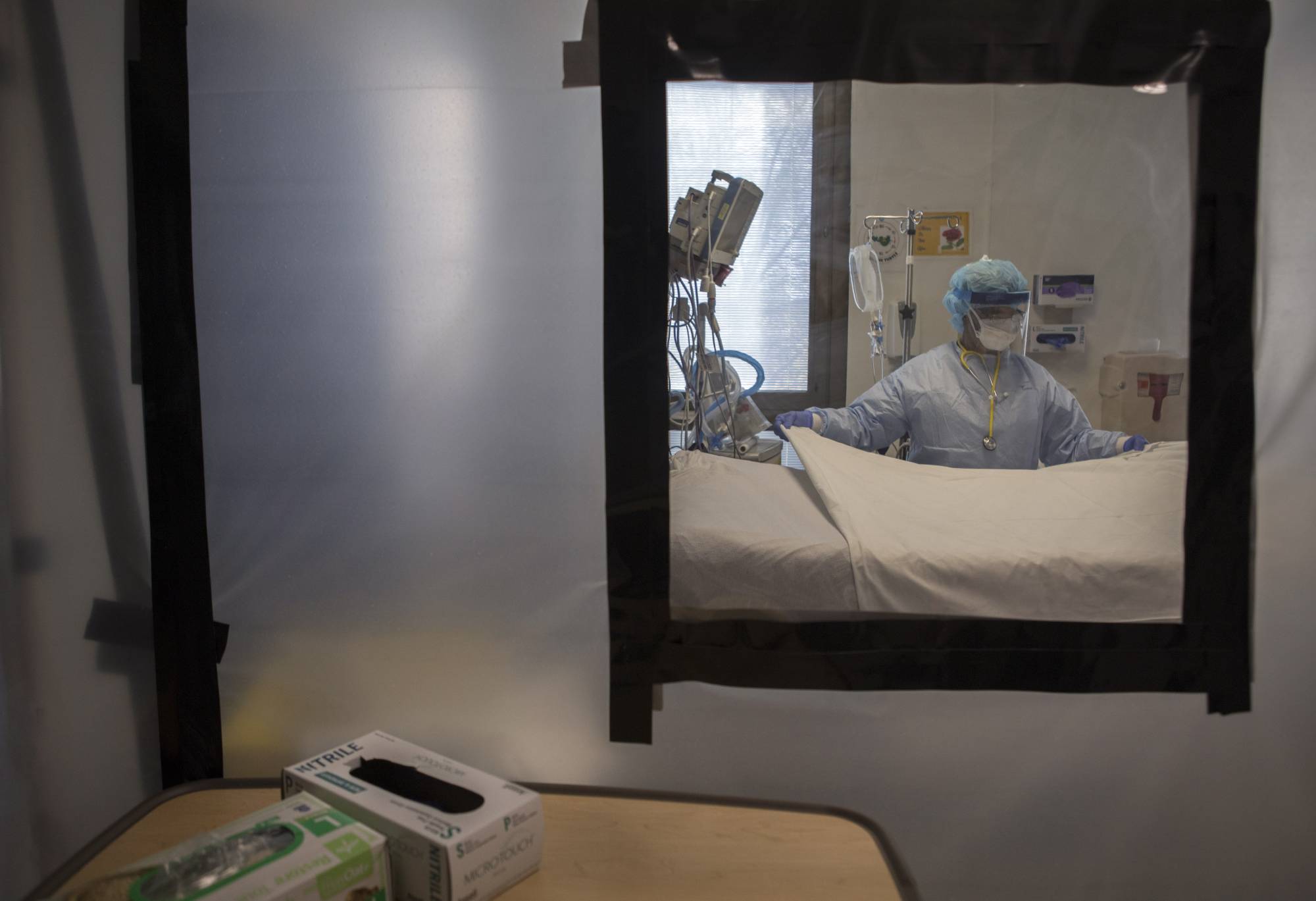 Plastic sheeting separates beds in a COVID-19 ward at University Hospital of Brooklyn in New York on April 22, 2020. In the U.S., the World Health Organization estimates that roughly 930,000 more people than normal had died by the end of 2021, compared with the 820,000 officially reported COVID-19 deaths over the same period. | Kirsten Luce / The New York Times