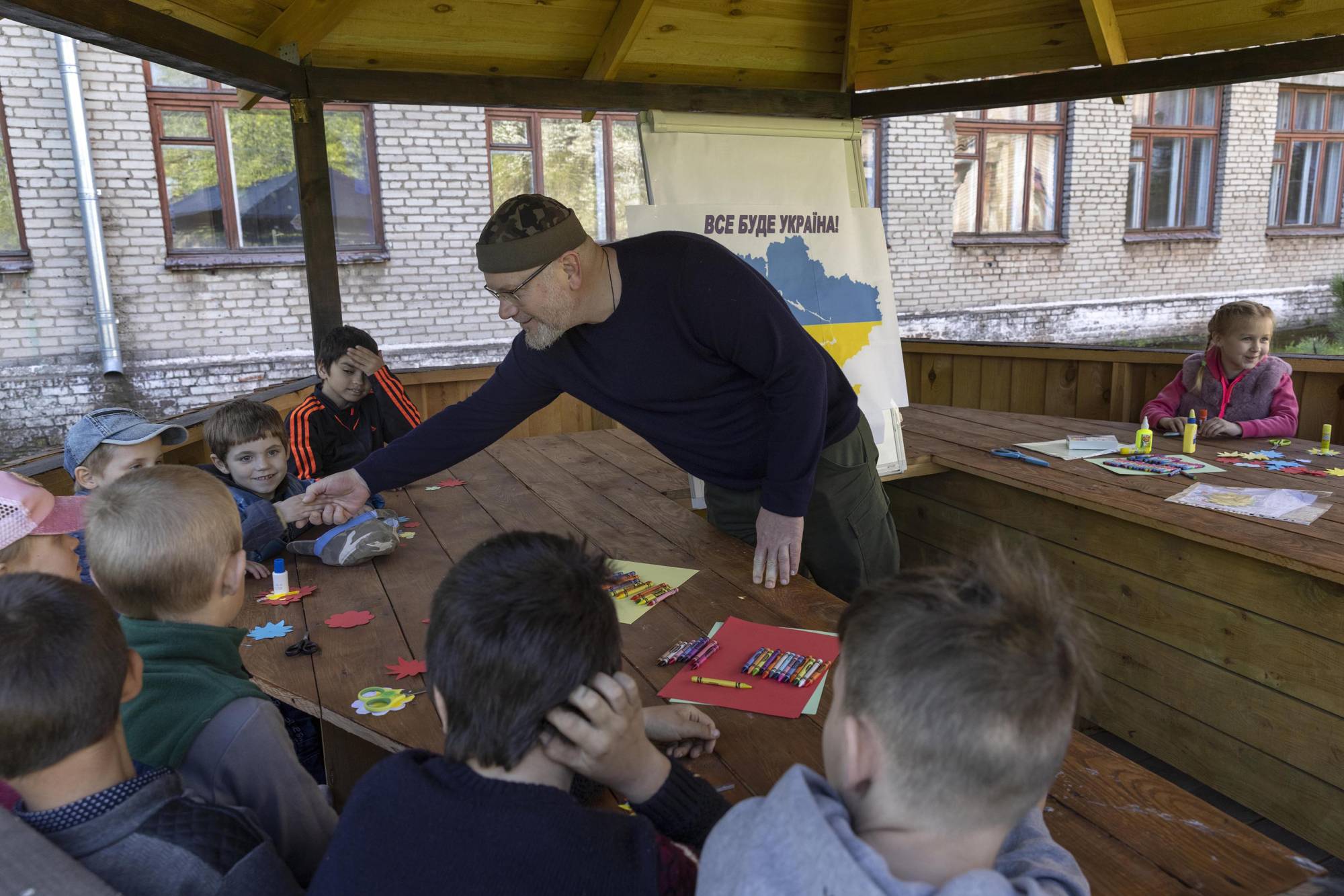 Oleksandr Vilkul greets children at a school that is being used to house evacuees in Kryvyi Rih on Saturday. | David Guttenfelder / The New York Times