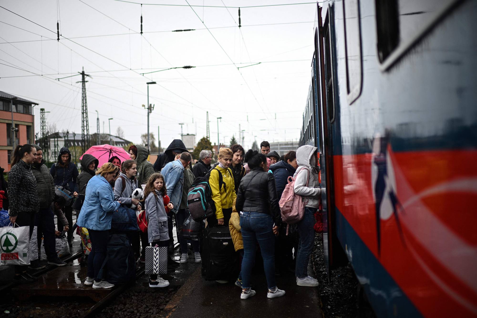 Ukrainian refugees board a train taking them back into Ukraine at the Zahony train station along the Ukrainian-Hungarian border on April 9. | AFP-JIJI