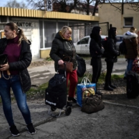 Ukrainian refugees wait before boarding a minibus to the Medyka border crossing along the Ukrainian-Polish border on their way back to Ukraine, outside the train station in Przemysl, eastern Poland, on April 7. | AFP-JIJI