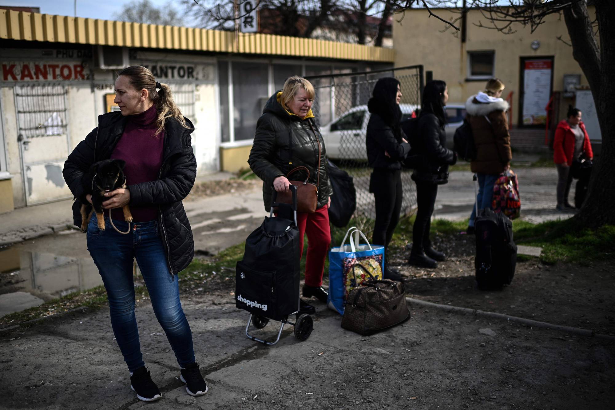 Ukrainian refugees wait before boarding a minibus to the Medyka border crossing along the Ukrainian-Polish border on their way back to Ukraine, outside the train station in Przemysl, eastern Poland, on April 7. | AFP-JIJI