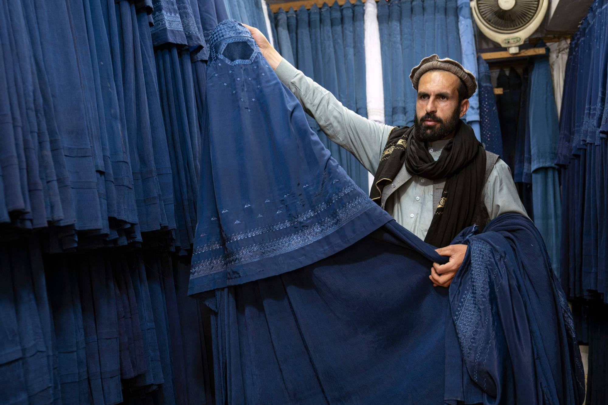 An Afghan vendor displays a burqa at his shop at Mandawi market in Kabul on Sunday. On May 7, the Taliban imposed some of the harshest restrictions on Afghanistan's women since they seized power, ordering them to cover up fully in public, ideally with the traditional burqa. | AFP-JIJI