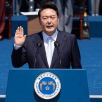 New South Korean President Yoon Suk-yeol takes the oath of office during his inauguration at the National Assembly in Seoul on Tuesday. | SIPA / VIA BLOOMBERG