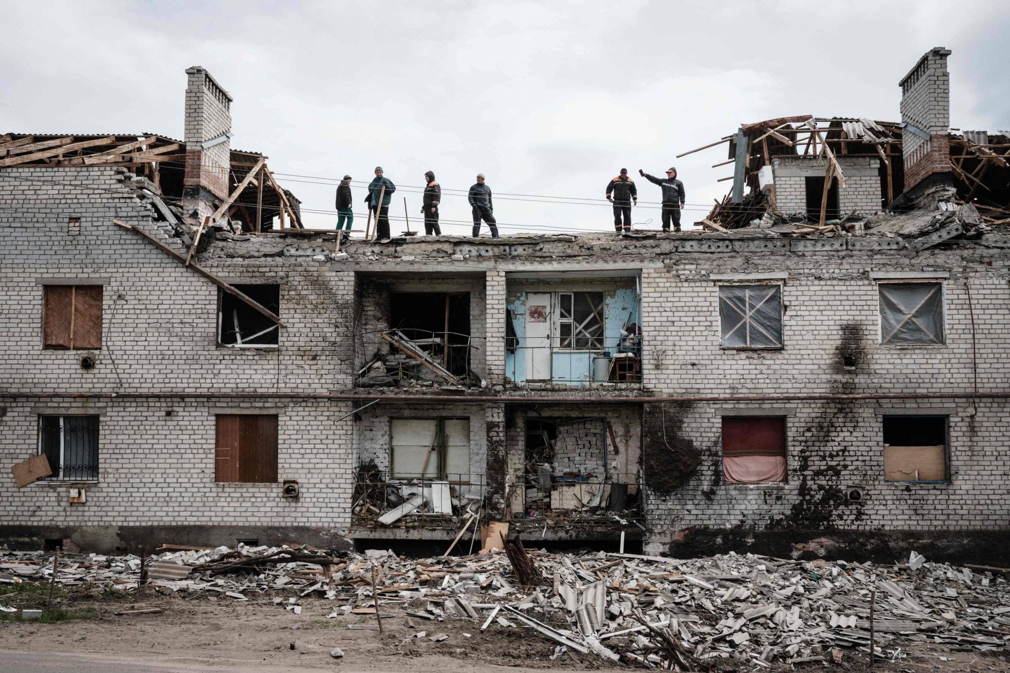 Workers clean rubble atop a building destroyed by shelling a month ago in Cherkaske, eastern Ukraine, on Wednesday | AFP-JIJI