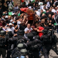 Family and friends carry the coffin of Al-Jazeera reporter Shireen Abu Akleh, who was killed during an Israeli raid in Jenin in the occupied West Bank, as clashes erupted with Israeli security forces, during her funeral in Jerusalem on Friday. | REUTERS