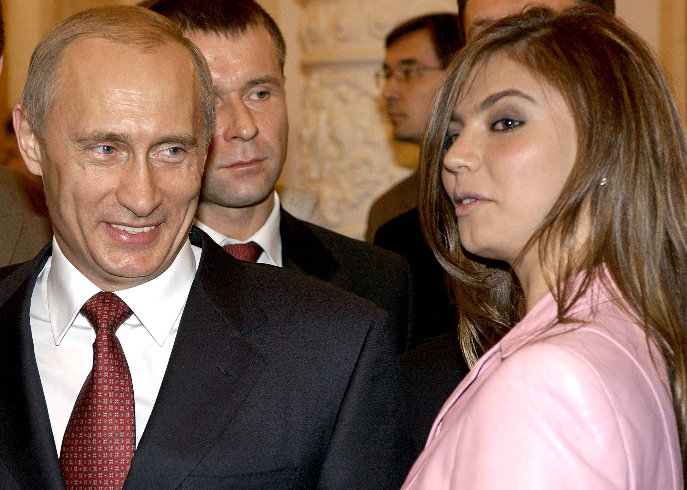 Russian President Vladimir Putin smiles next to Russian gymnast Alina Kabaeva during a meeting with the Russian Olympic team at the Kremlin in Moscow in November 2004. | ITAR-TASS / PRESIDENTIAL PRESS SERVICE / VIA REUTERS