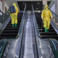 Employees spray disinfectant as part of preventative measures against COVID-19 at the Pyongyang Children\'s Department Store in the North Korean capital on March 18. | AFP-JIJI