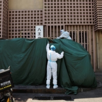 Workers sort boxes near a waste-sorting facility outside a residential compound in Beijing under a COVID-19 lockdown on Monday. | REUTERS