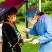 A resident registers for a COVID-19 test at a compound under lockdown in Shanghai on Friday. | AFP-JIJI