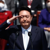 South Korean President Yoon Suk-yeol salutes during his inauguration in front of the National Assembly in Seoul on May 10. | POOL / AFP-JIJI