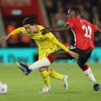 Liverpool\'s Takumi Minamino contends for the ball with Southampton\'s Mohammed Salisu during their Premier League game in Southampton, England, on Tuesday. | REUTERS