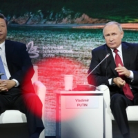 Russian President Vladimir Putin speaks as he sits beside Chinese President Xi Jinping during the Eastern Economic Forum in Vladivostok, Russia, in September 2018. | BLOOMBERG