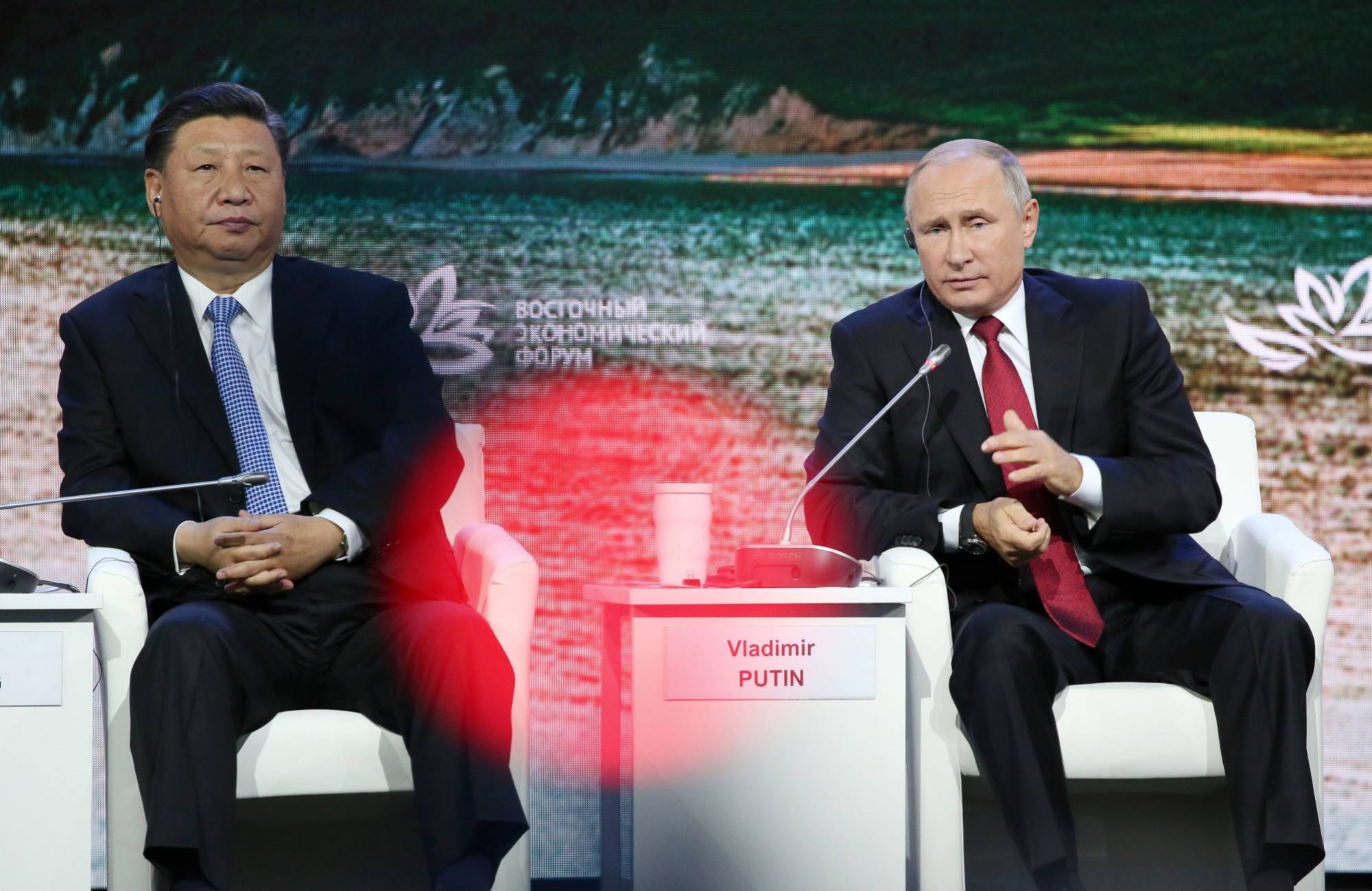 Russian President Vladimir Putin speaks as he sits beside Chinese President Xi Jinping during the Eastern Economic Forum in Vladivostok, Russia, in September 2018. | Bloomberg