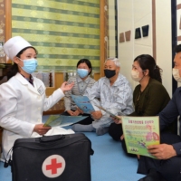 A doctor promoting epidemic prevention measures to prevent the spread of the COVID-19 in Pyongyang on Tuesday. | KCNA / VIA KNS / AFP-JIJI